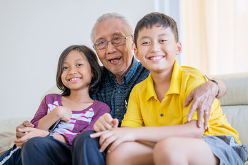 Happy grandfather hugs his grandchildren