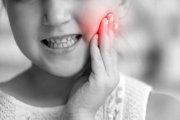 Little girl suffering from toothache, closeup