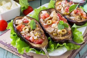 Thanksgiving Autumn Menu. Baked Stuffed Eggplant with Olives, Feta Cheese and Vegetables on a Rustic Table.