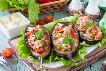 Thanksgiving Autumn Menu. Baked Stuffed Eggplant with Olives, Feta Cheese and Vegetables on a Rustic Table.