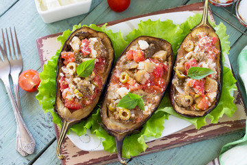 Thanksgiving Autumn Menu. Baked Stuffed Eggplant with Olives, Feta Cheese and Vegetables on a Rustic Table.