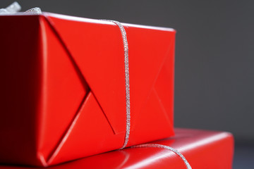 Element of Christmas red gift boxes with silver ribbons on blurred gray background