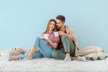 Portrait of happy young couple drinking tea indoors