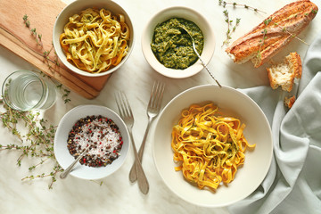 Tasty pasta with pesto sauce and spices on table