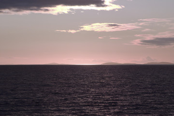 Obraz premium Image of the sunset hidden by clouds over the sea