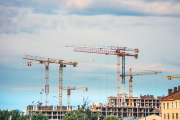 Fototapeta na wymiar Industrial construction cranes operating on construction site