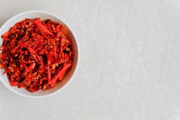 Fried red peppers in a bowl on a white background, snack food.