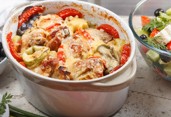 Traditional tasty rustic stew of chicken and vegetables  with Greek salad and black olives