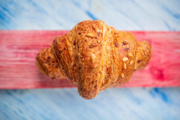 Croissant on a light wooden background. Photographed close-up.