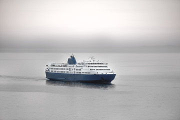 Fototapeta na wymiar Sunset and a blue white ferry boat in greek islands