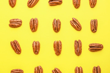 Tasty pecan nuts on color background