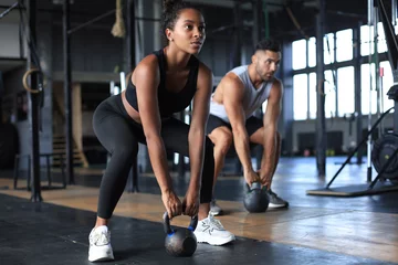 Foto auf Acrylglas Bestsellern Sport Fit und muskulöses Paar konzentrierte sich auf das Heben einer Hantel während eines Trainingskurses in einem Fitnessstudio.