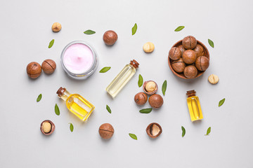 Macadamia nuts with oil and cream on light background