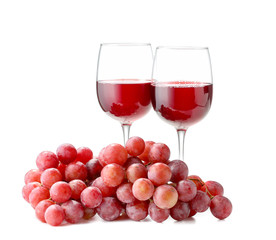 Glasses of wine and grapes on white background