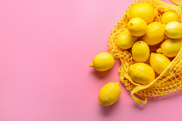 Fototapeta na wymiar Bag with ripe lemons on color background