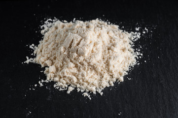 White sports nutrition powder. Soluble protein to increase athlete's stamina and strength. On a stone gray background.