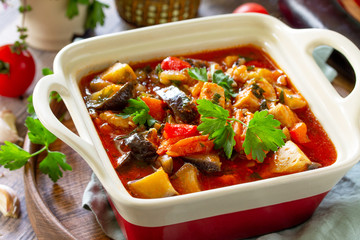 Thanksgiving Autumn Menu. Stewed meat with eggplant and eggplant vegetables on a rustic table.