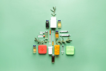 Beautiful Christmas tree made of medicines on color background