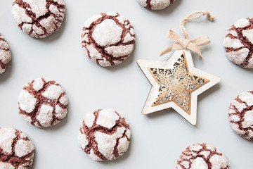 Chocolate crinkle cookies and Christmas tree decoration on grey backround.