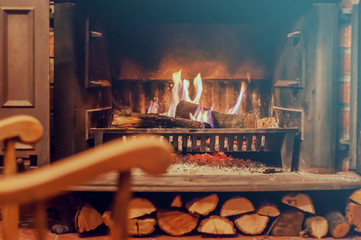 Home comfort. Rocking chair near the fireplace. Photo of interior of room. Rocking chair in the living room with decorated modern fireplace