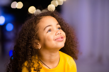 Dreamy african american little girl looking at free space
