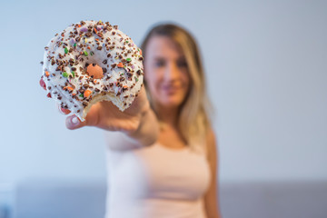 Close up portrait of a satisfied pretty girl eating donuts