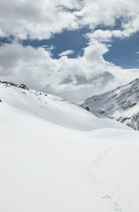 Obraz premium Snowy mountains and clouds in the sky on a sunny day