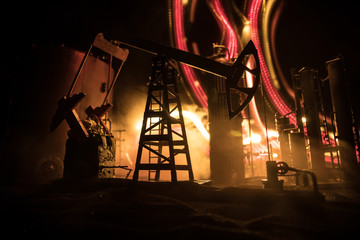 Artwork decoration. Oil pump and oil rig energy industrial machines for petroleum at night with fog and backlight. Oil refining factory. Energy industrial concept. Selective focus