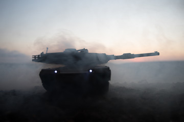 War Concept. Armored vehicle silhouette fighting scene on war fog sky background. American tank at...