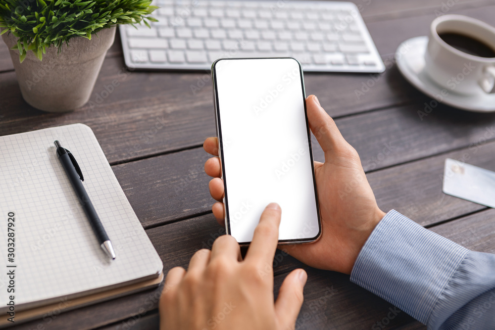 Poster unrecognizable man using modern smartphone with blank screen at workplace