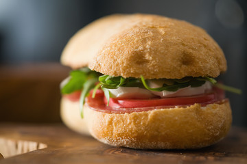 ciabatta sandwich with salami and mozzarella cheese on olive board - obrazy, fototapety, plakaty