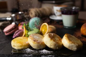 sweets and desserts. Cheesecakes with powdered sugar, chocolate, pasta, pudding and pasta on black