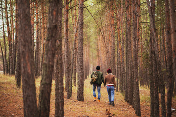 romantic couple, a guy and a girl walk in the autumn cold forest and drink tea
