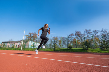 Young female runner training in summer day outdoors on the studium