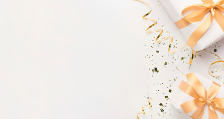 White gift boxes wrapped in gold bow on white background