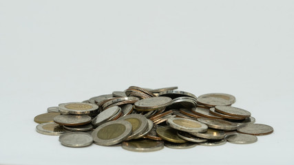 Many coins stacked on a white background