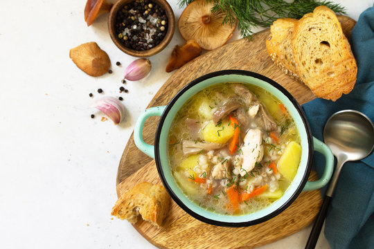 Homemade Hot Vegetable Soup With Chicken, Mushrooms And Bulgur On A White Countertop. Top View Flat Lay Background.