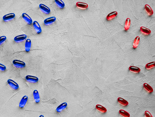 Red and blue pills isolated on gray background with copy space. Concept of pharmacology,...