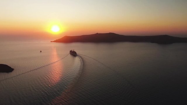 Aerial 4k Footage Cruise ship leaving the port Santorini in the sunset