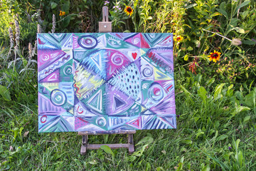 Easel with the oil painting on canvas. Abstract shape and line artistic texture. Modern artwork.