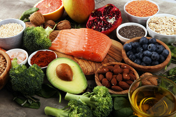 Healthy food clean eating selection: fish, fruit, vegetable, cereal, leaf vegetable on rustic background