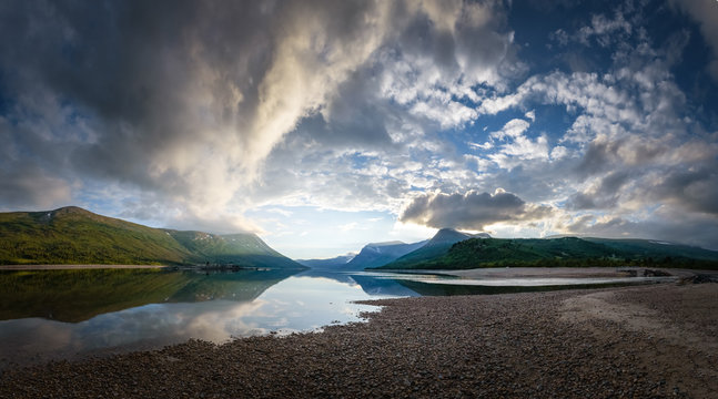 The gaint mountains of Trollheimen national park at sunset with reflection in lake Norway