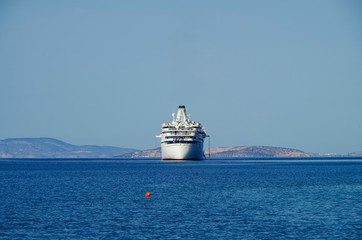 Classic small cruise ship MS Ocean Majesty anchoring in bay on blue sea of Greek Island during...