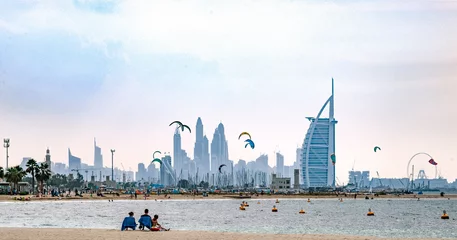 Foto op Canvas Vakantie strandscène uit Dubai met vliegers en hoogbouw op de achtergrond. © Plamen