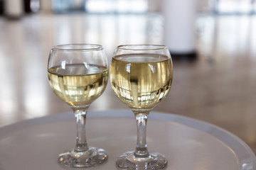 Two glasses of white wine in a hotel lobby, selective focus