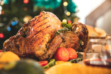 Roasted  chicken or turkey with sauce and grilled autumn vegetables: corn,pumpkin  on wooden table, top view, frame. Christmas or Thanksgiving Day food concept.