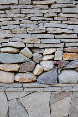 The texture of stones of different shapes. Grey granite stones and shapeless colored stones.