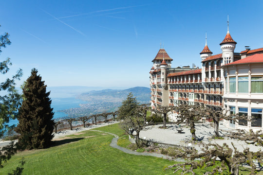 Beautiful picture of the SHMS Swiss Hotel Management School in Switzerland (Caux-Montreux). Sunny day, blue sky and luxurious green grass. Impressive architecture.