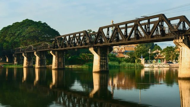 4K Time lapse of sunrise over railway crossing river Kwi. Kanchanaburi, Thailand. Historical raiway during world war II. Camera zoom out.