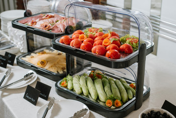 Served buffet table with vegetables, cheese and meat indoor the restaurant